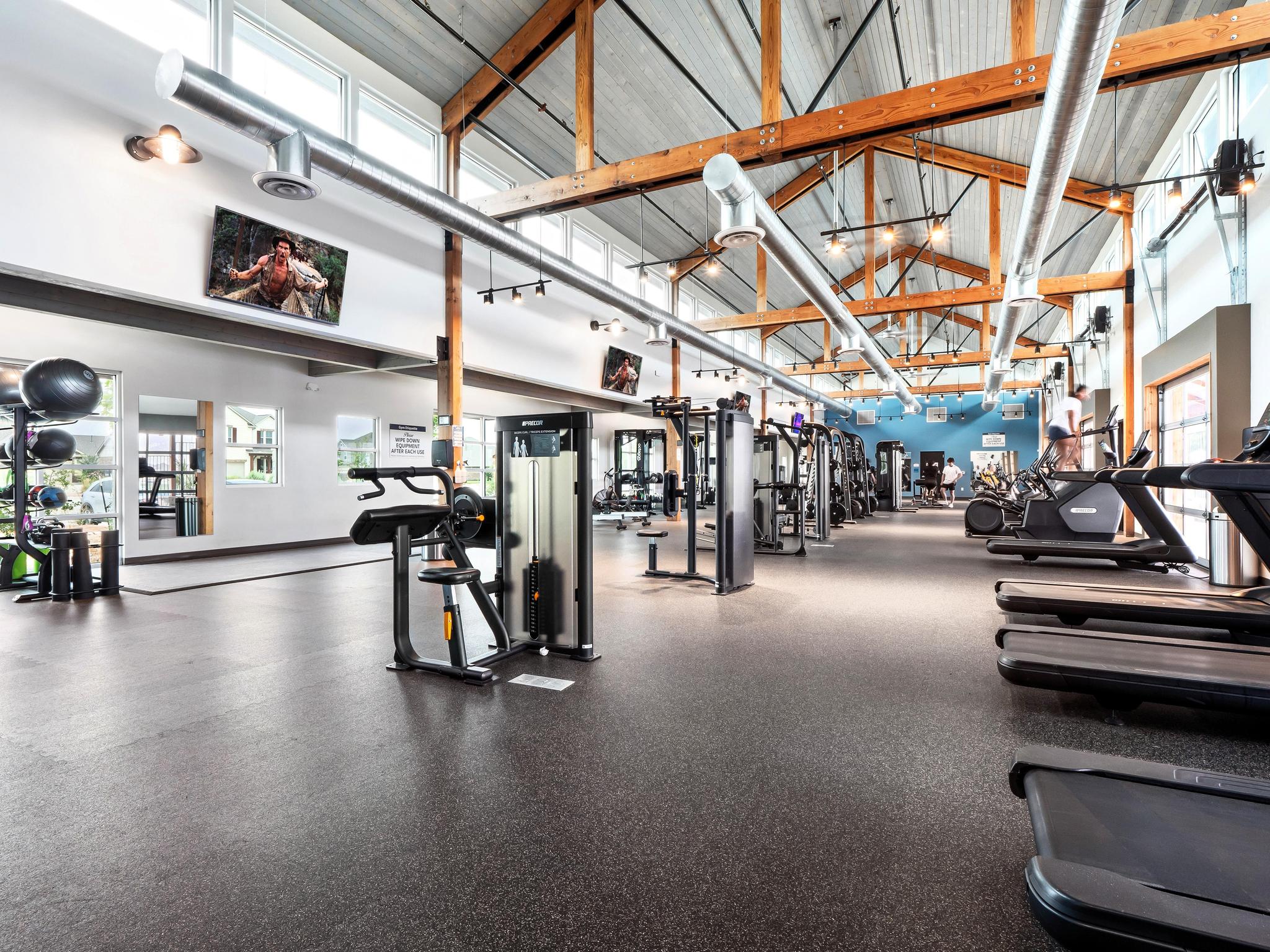 Carries Ranch Recreation Center fitness center with cardio machines, strength equipment, and wood beam ceiling.
